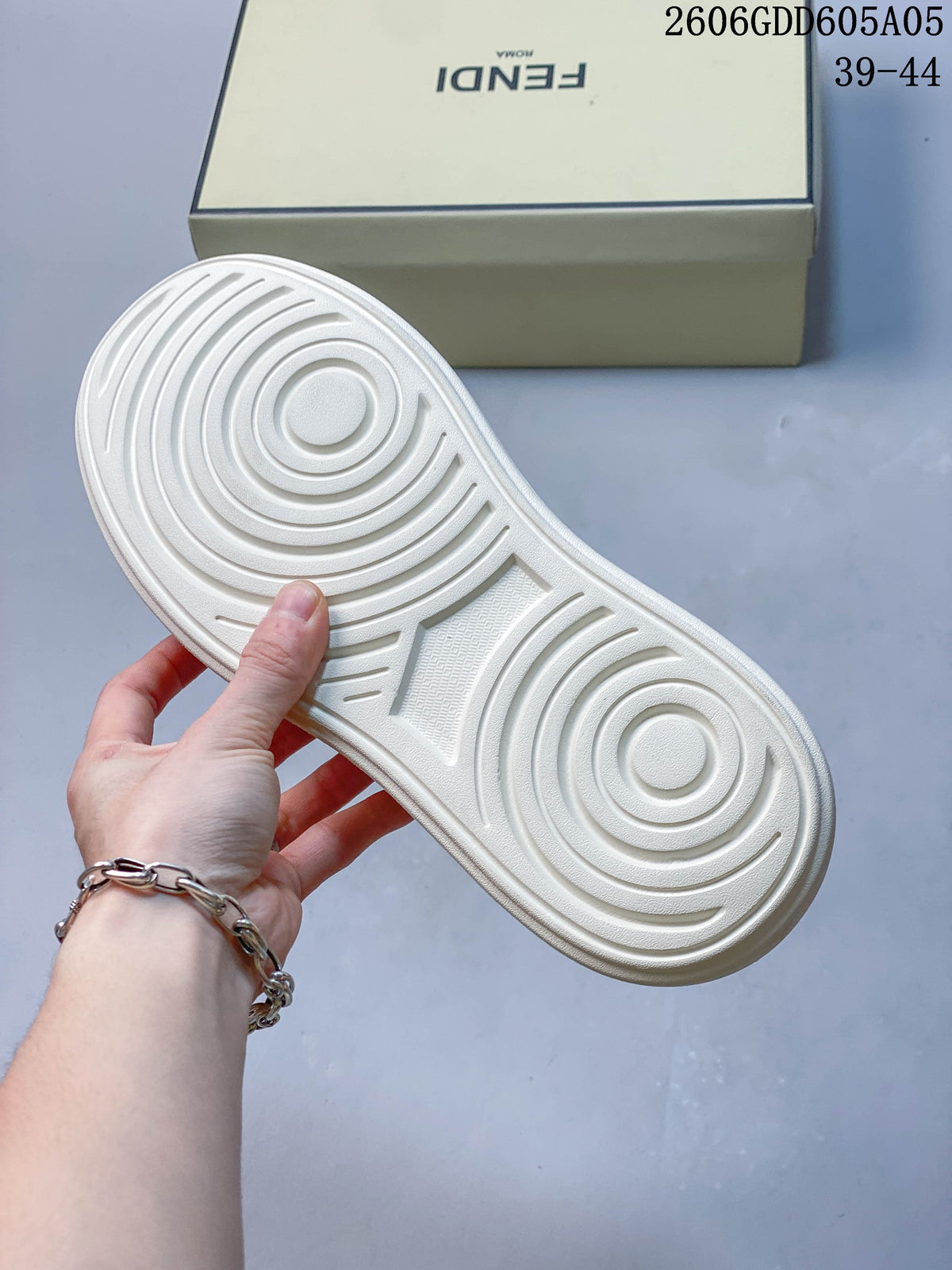 Underside of a cream sneaker showing a circular tread pattern