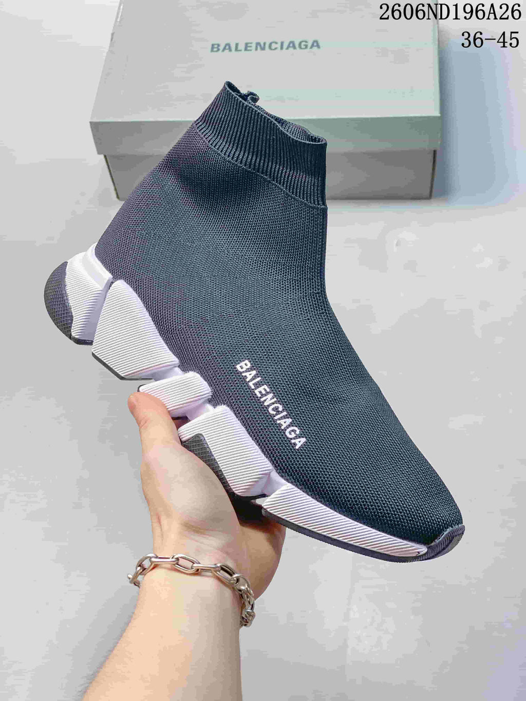 Side view of a dark blue knit sock sneaker with a white segmented sole
