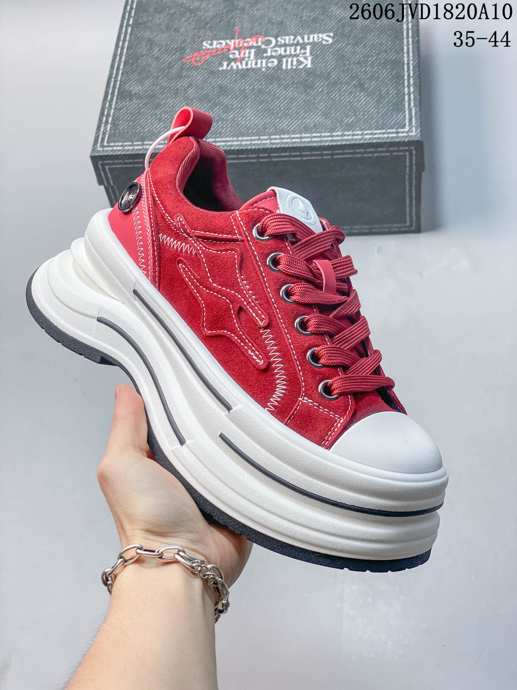 Angled side view of a red low-top sneaker with a chunky white platform sole