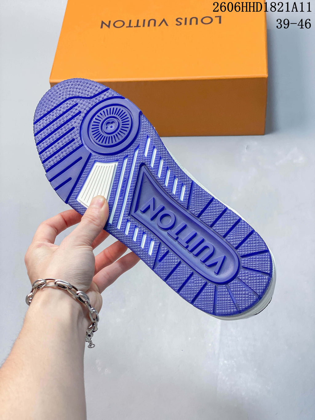 Blue patterned outsole of a white LV Trainer sneaker.