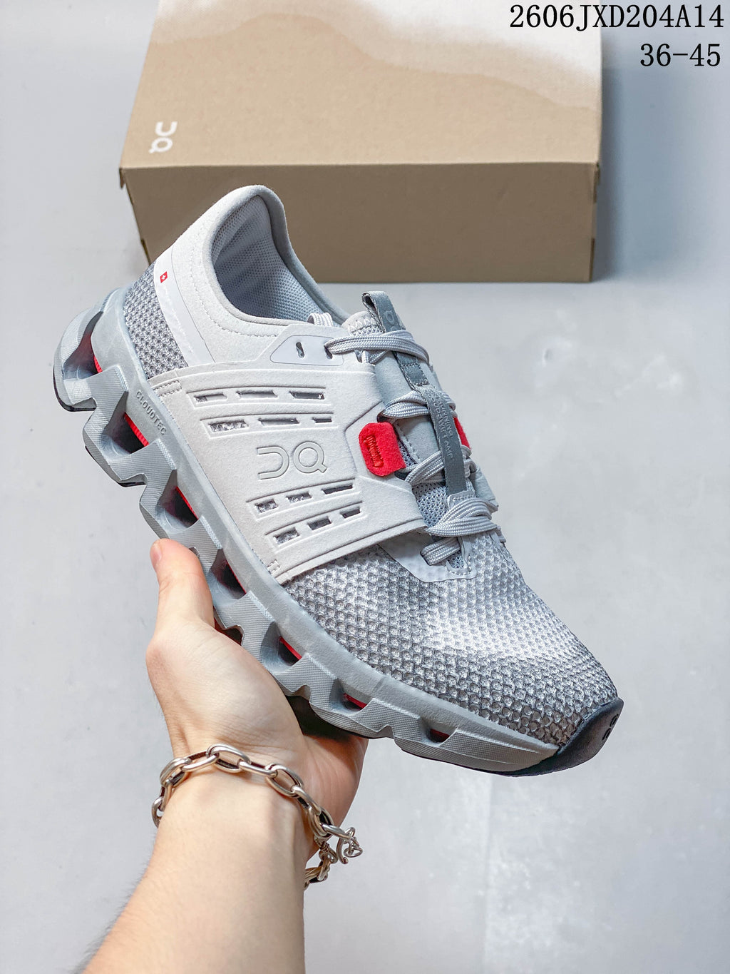 Side view of a light gray running shoe with red accents