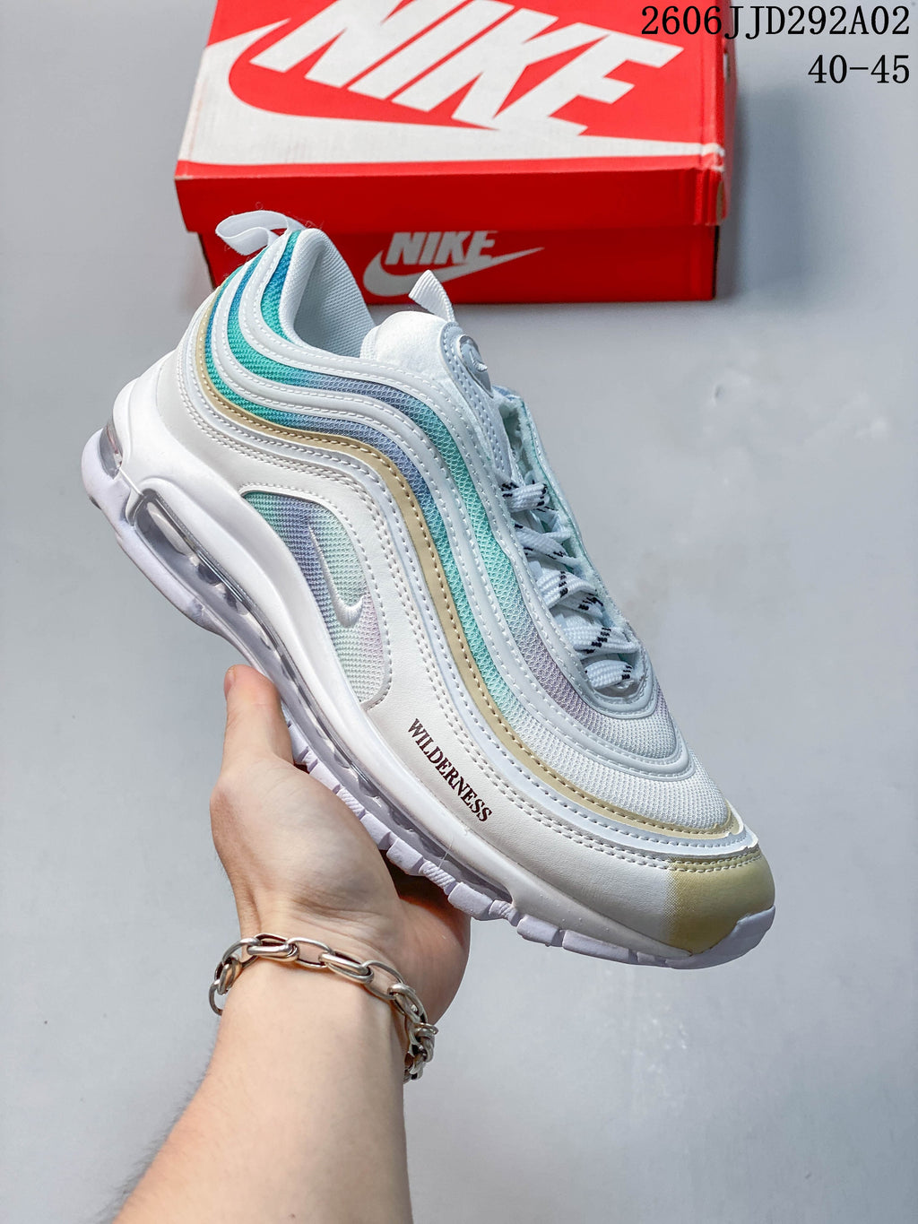 Angled side view of a Nike Air Max 97 sneaker with white and aqua panels and a visible Air unit