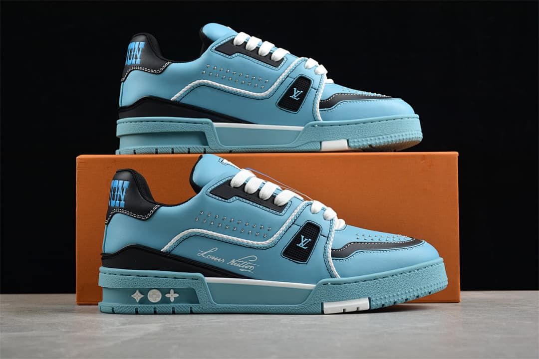 Pair of blue and navy LV Trainer sneakers displayed against an orange box