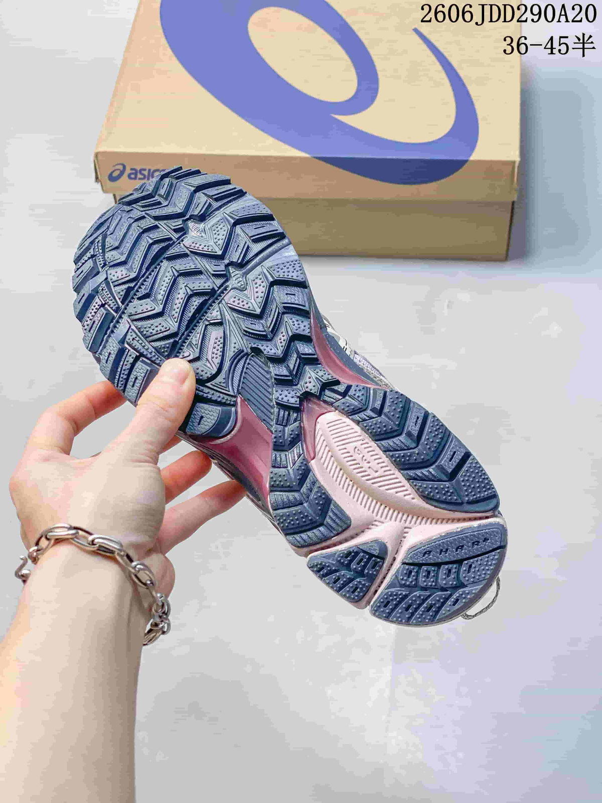 Close-up of the patterned outsole on a gray and pink ASICS Gel-Kahana 8 shoe.