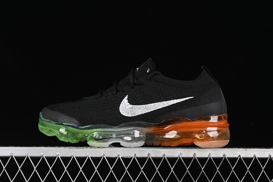 Side view of a black Nike Air VaporMax sneaker with a white Swoosh and colored transparent sole.