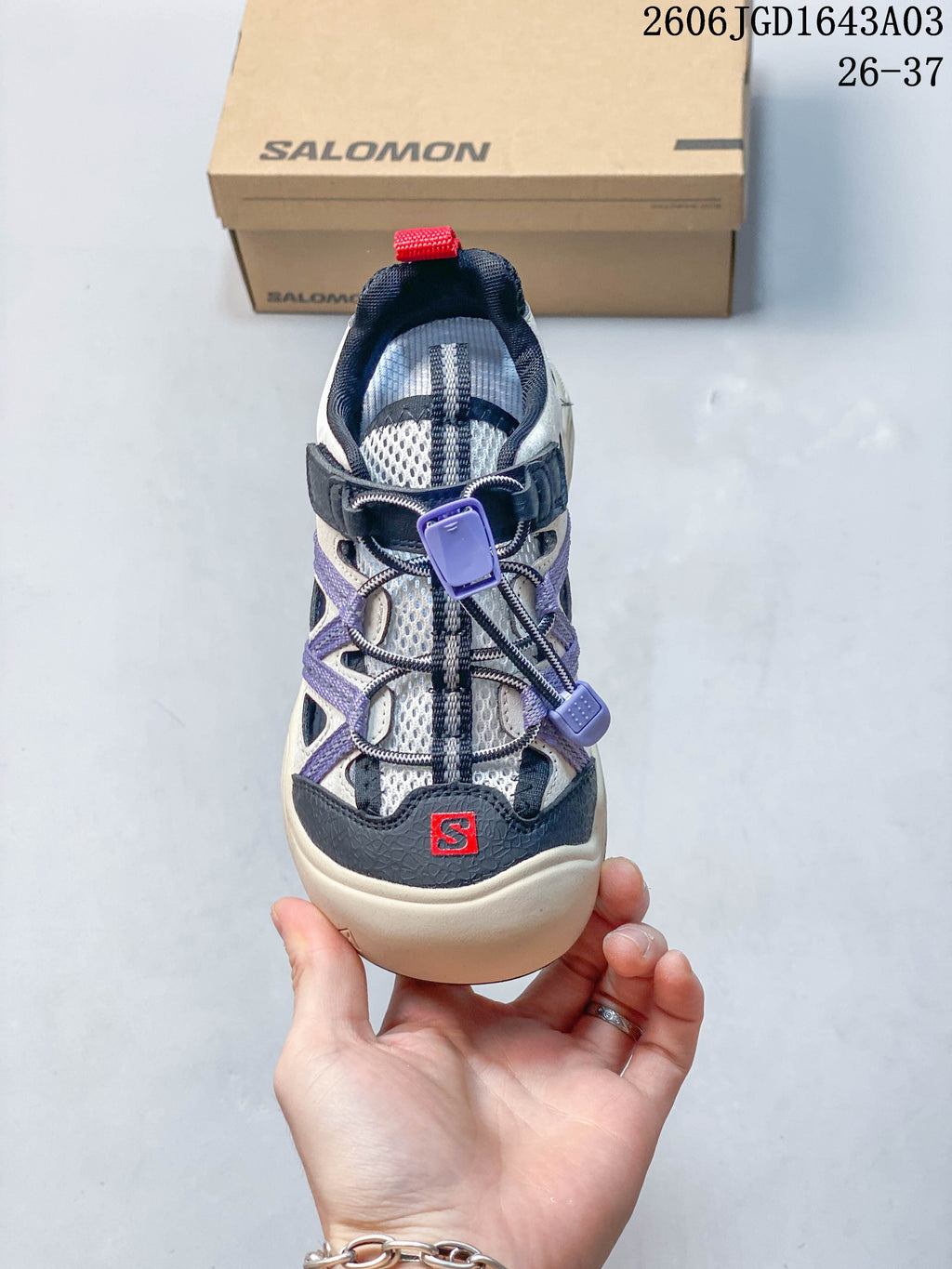 Top view of a Salomon kids' sneaker showing its quick-lace closure and red details