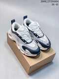 Pair of white and navy On Cloudtilt sneakers on a box