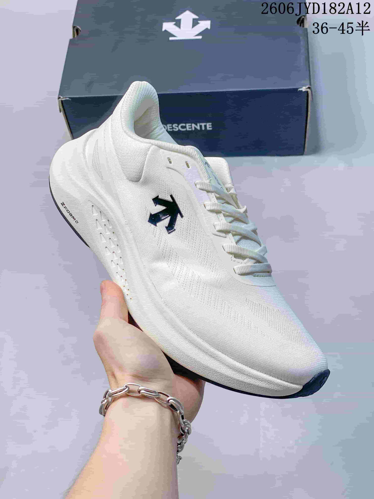 Angled side view of the white Descente sneaker with dark outsole accents.