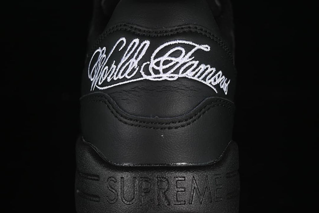 Heel close-up showing white embroidered script and embossed Supreme lettering