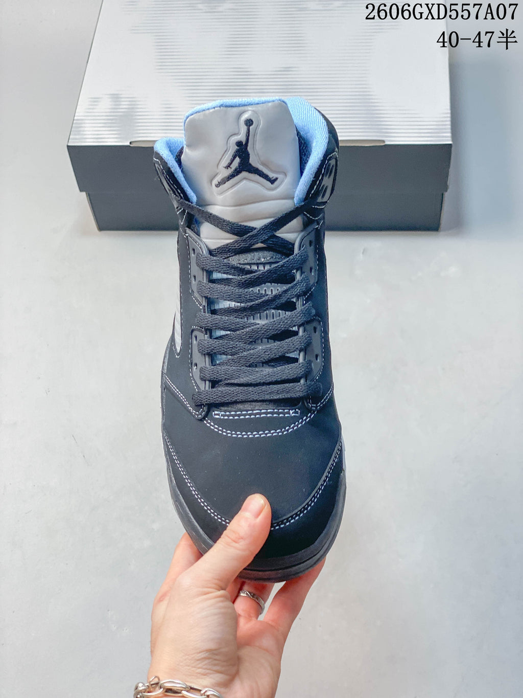 Front view of a Jordan Air Jordan 5 sneaker showing its tongue emblem and dark lace-up front.