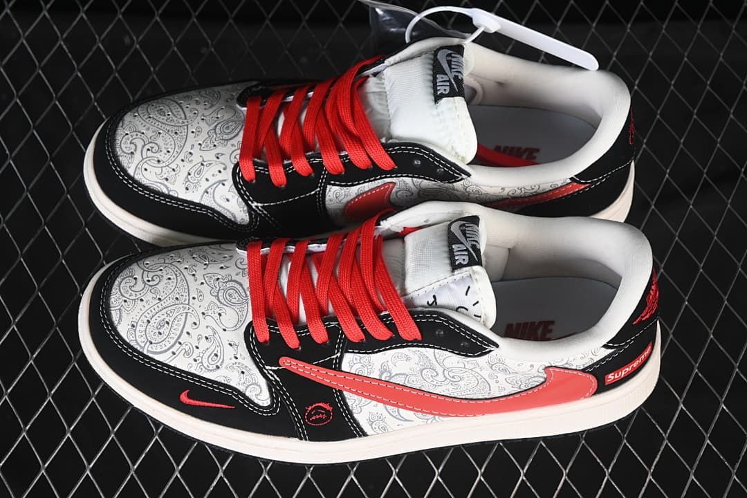 Overhead view of a pair of low-top sneakers with paisley-patterned panels, black overlays and red laces