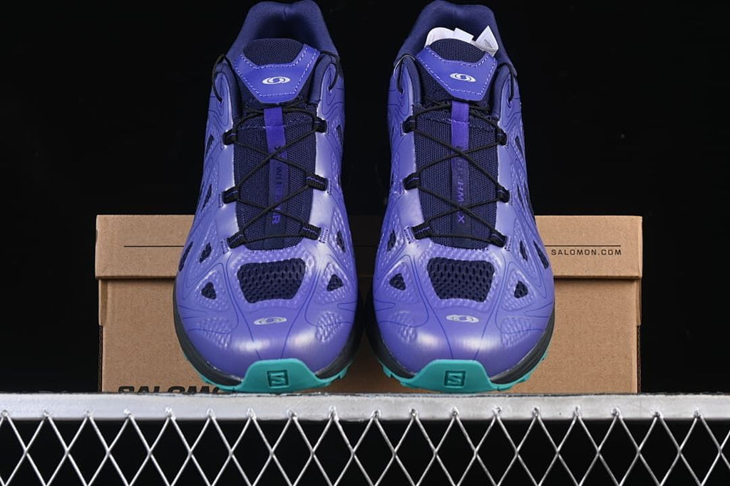 Front view of the pair showing purple uppers and turquoise toe outsoles.