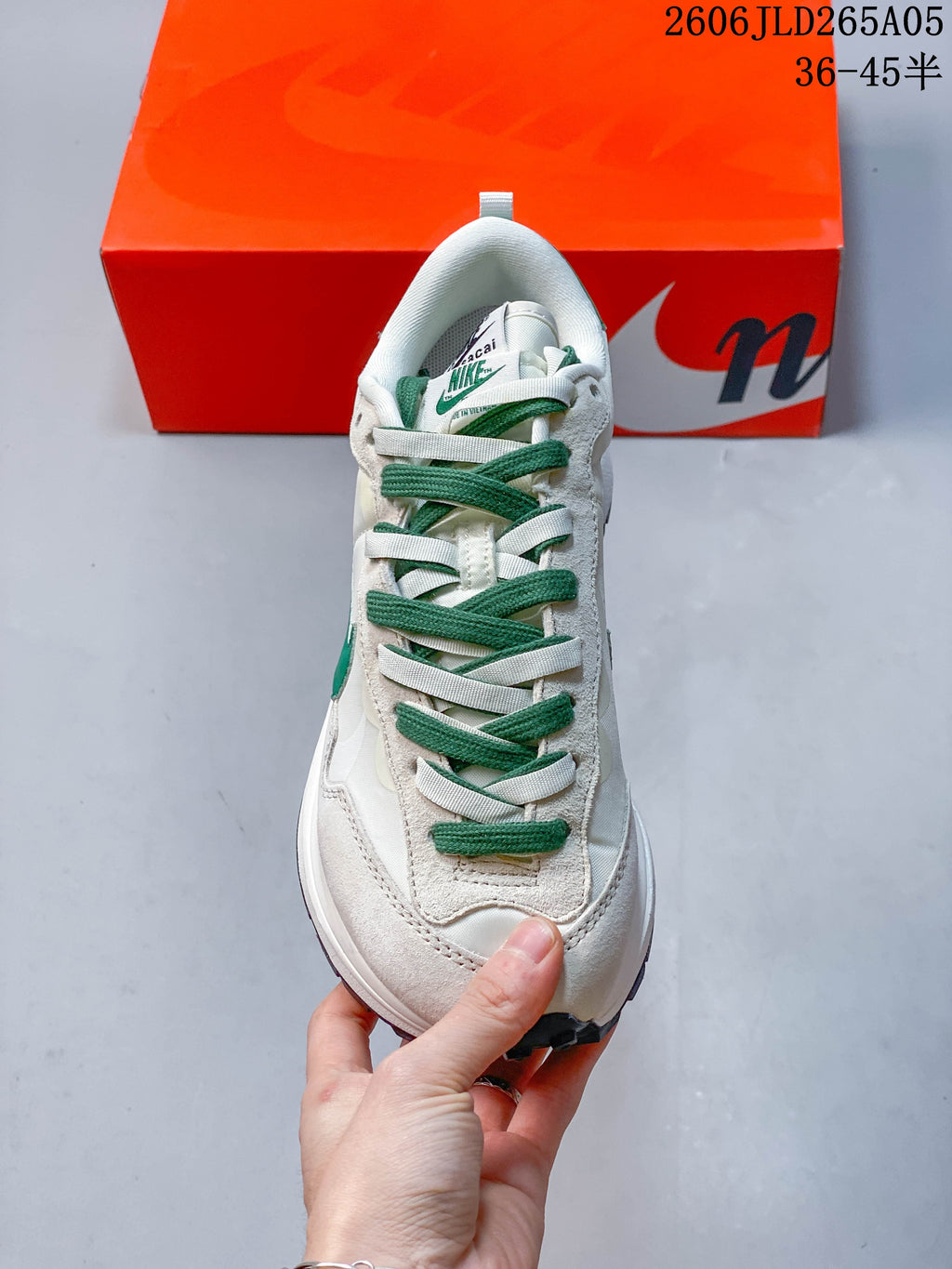 Front view of the sneaker with alternating green and white laces.