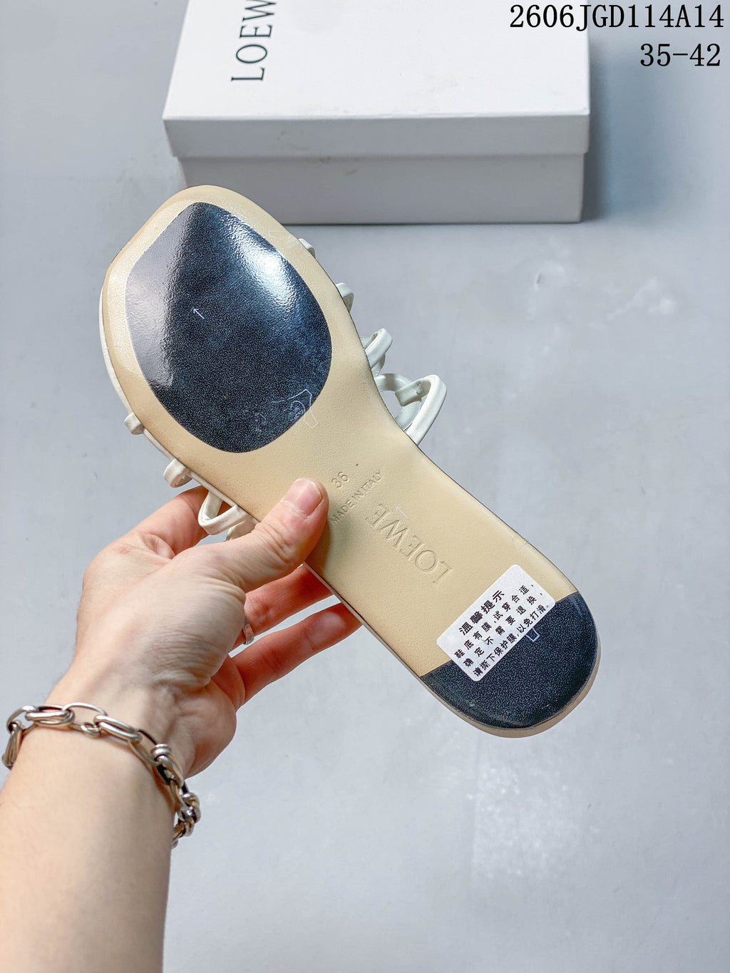 Underside of a white slide sandal showing the footbed, outsole pads, and size 36