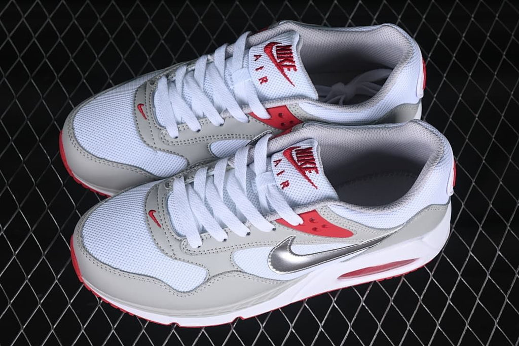 Pair of white, grey, and red sneakers shown from above at an angle.