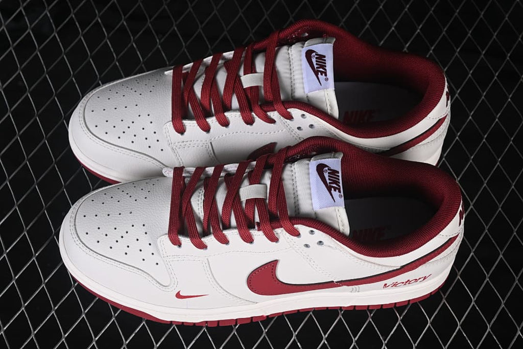 Pair of white and deep red Nike SB Dunk Low sneakers shown from above