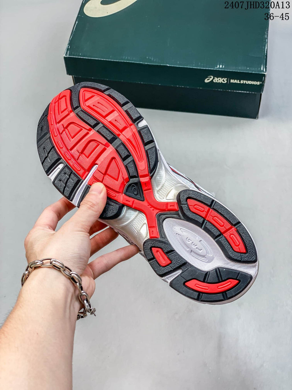 Underside of a sneaker showing a red, black, and white patterned outsole