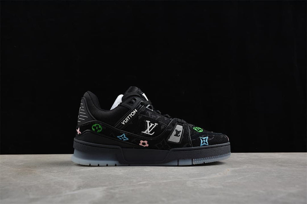 Side profile of the black sneaker with decorative motifs and pale outsole