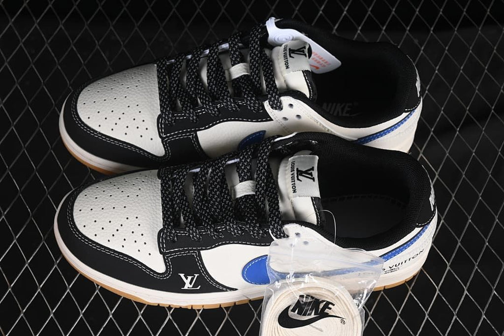 Top view of a pair of white, black, and blue low-top sneakers with perforated toe panels, patterned black laces, and an extra lace set.