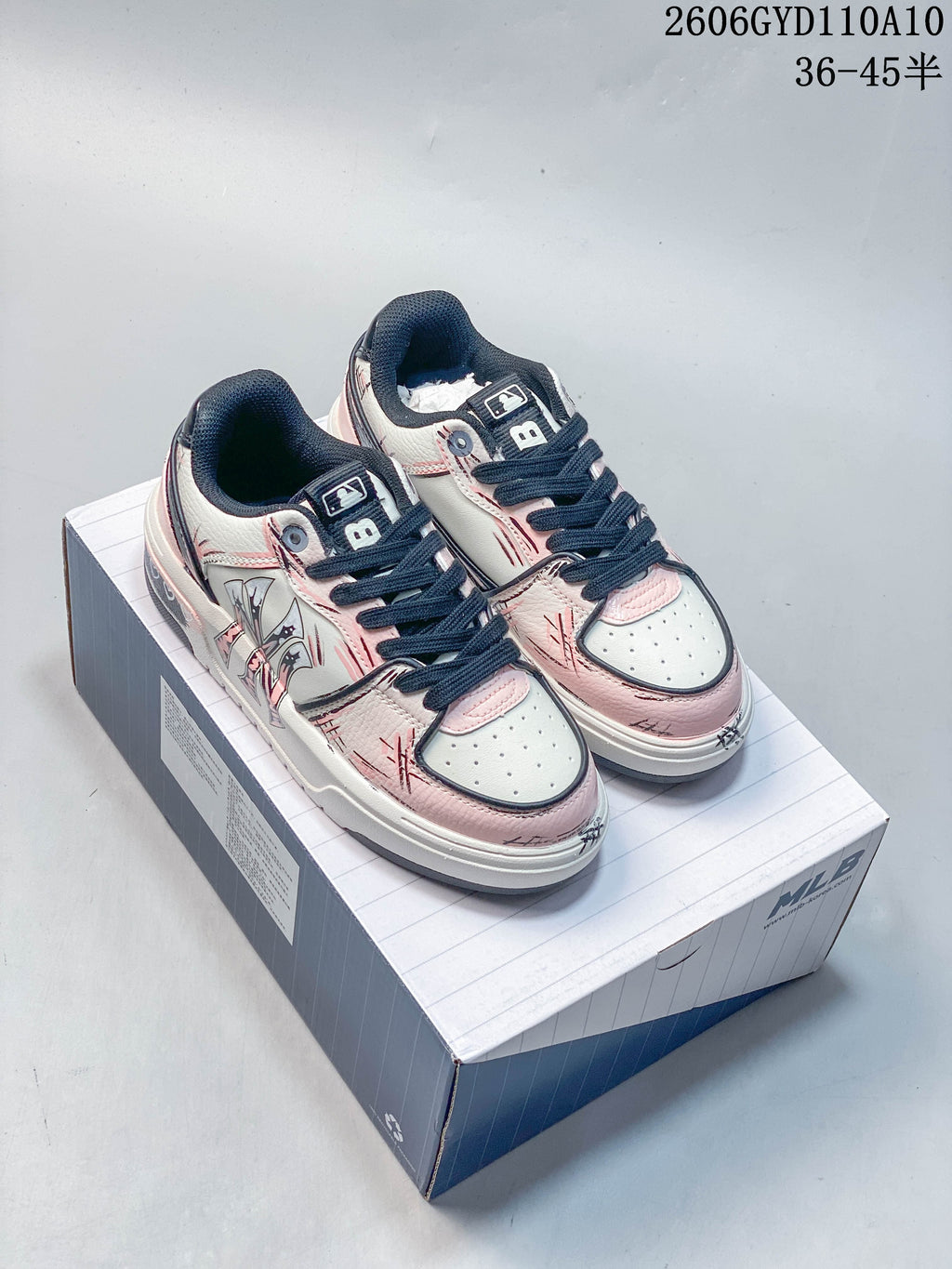 Pair of white and pink MLB Chunky Liner low-top sneakers with navy laces on a shoe box