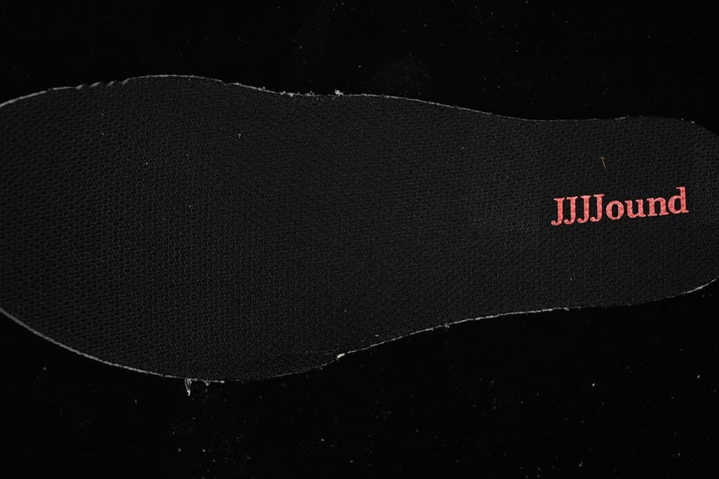 Black shoe insole with JJJJound lettering
