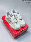 White low-top sneakers with decorative details shown on a red box.