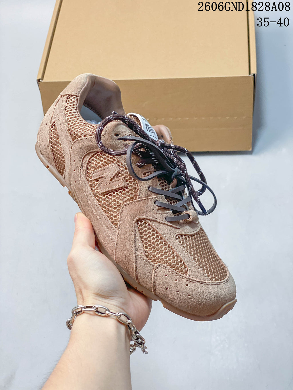 Close view of a tan sneaker with mesh panels, textured overlays, contrast laces and side branding.