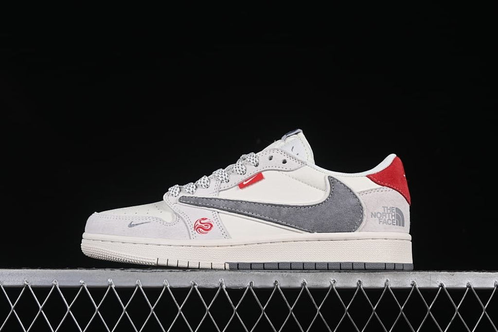 Side view of a cream, gray, and red low-top sneaker with patterned laces and a large gray side swoosh.