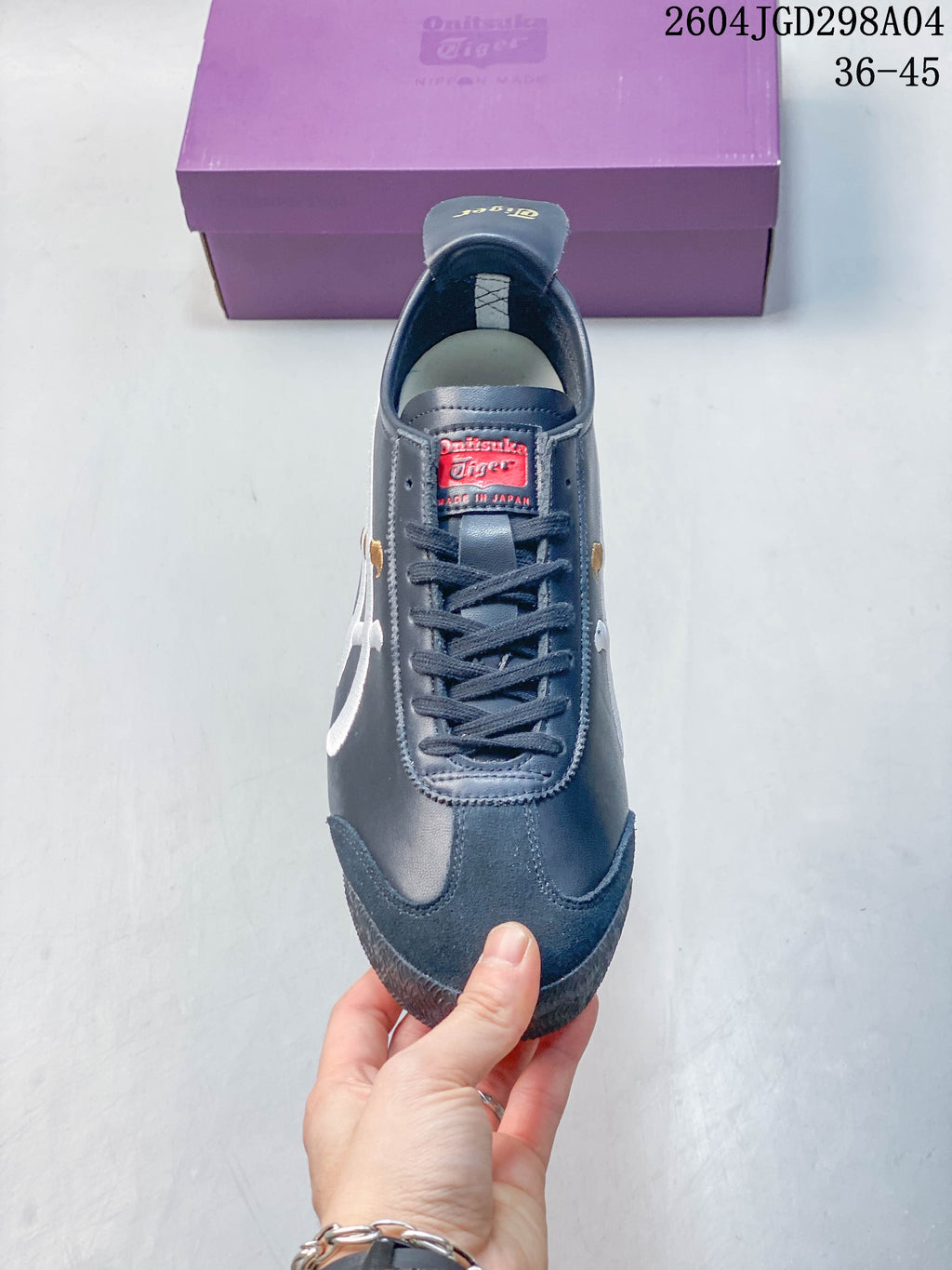 Front view of a navy lace-up sneaker with contrasting side stripes