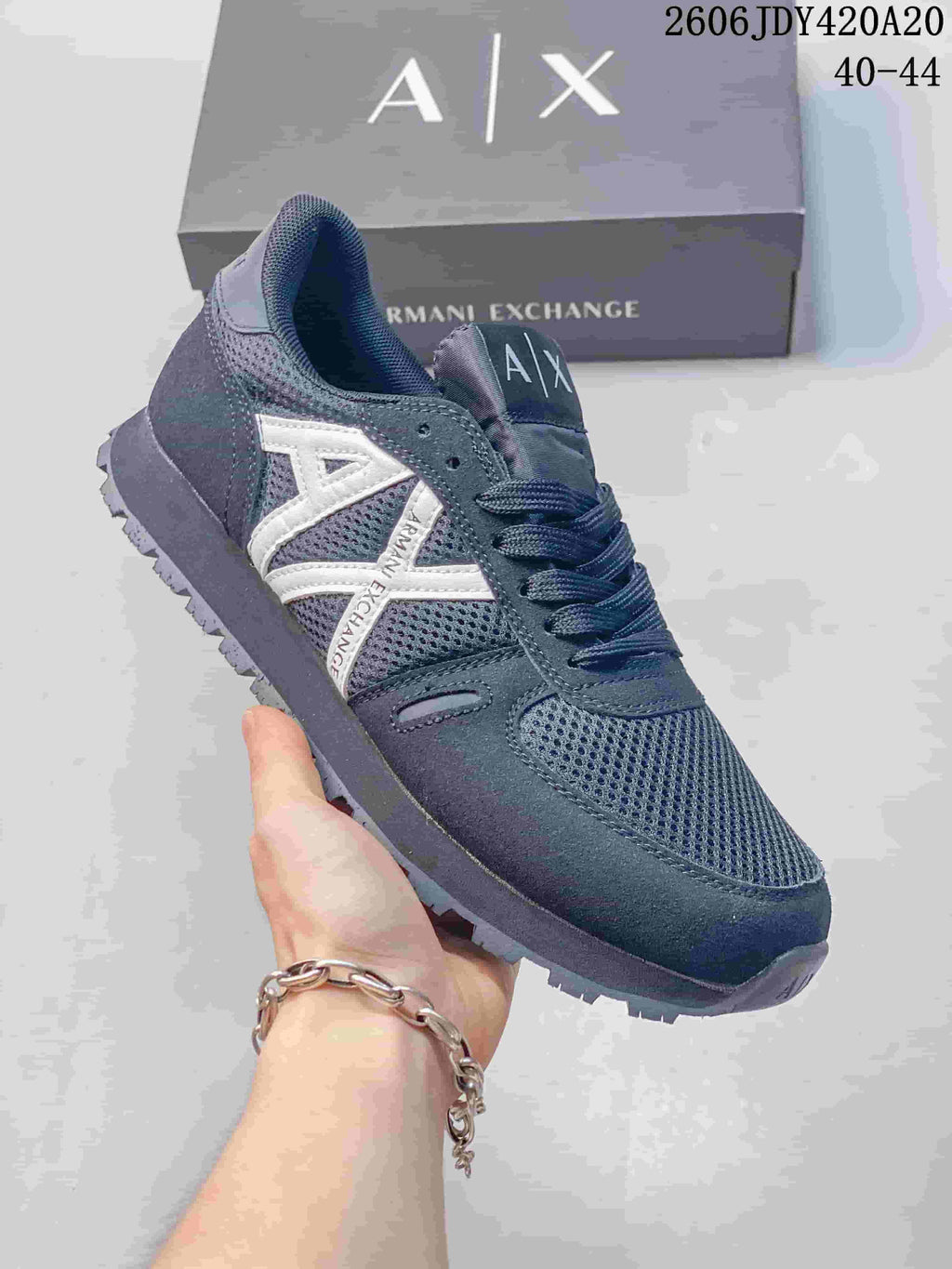 Angled side view of a navy mesh sneaker with white logo detailing