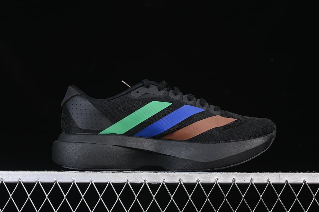 Side profile of a black shoe with green, blue, and brown accents.