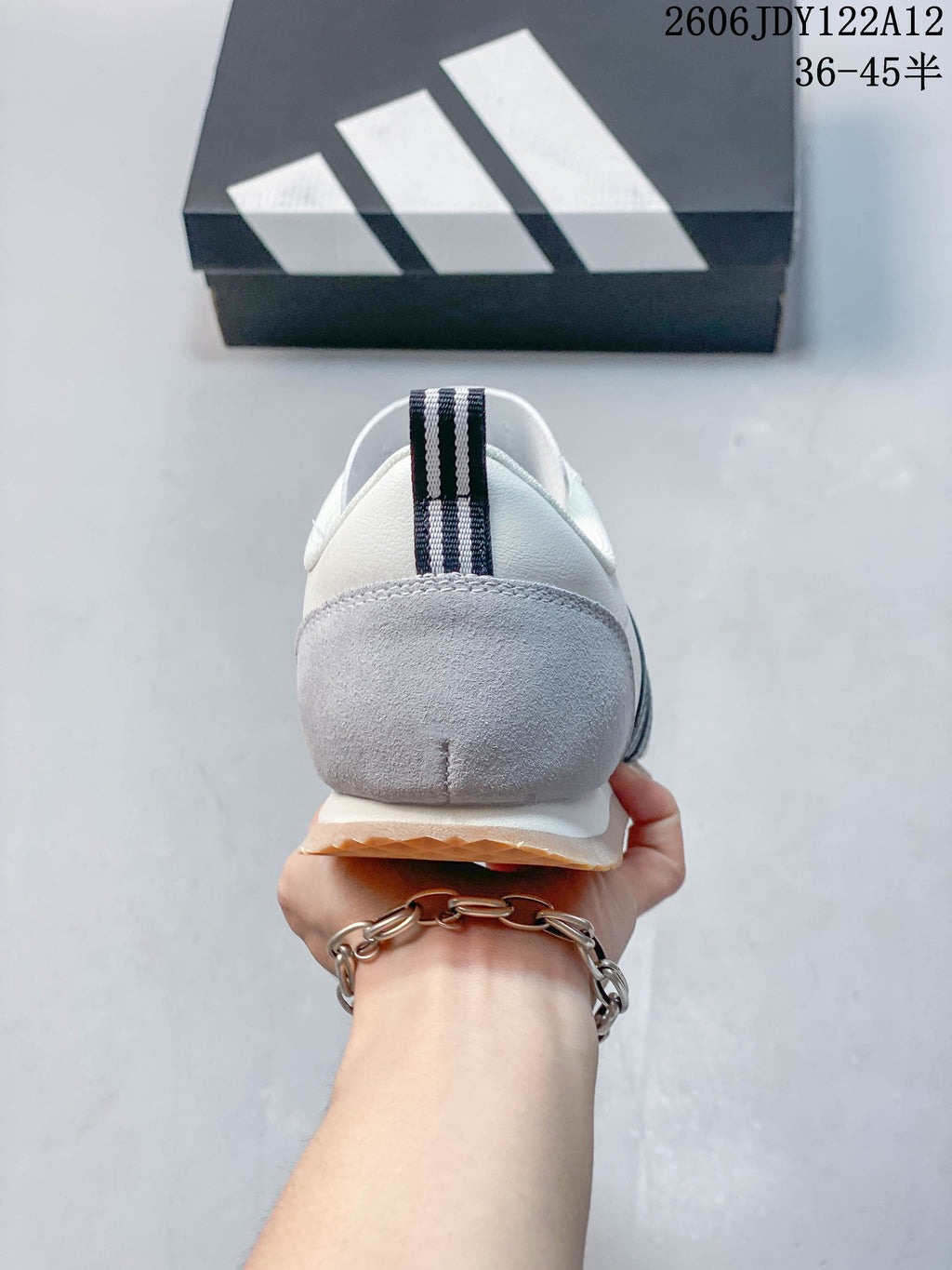Rear view of the sneaker showing a gray heel overlay and striped heel pull tab.