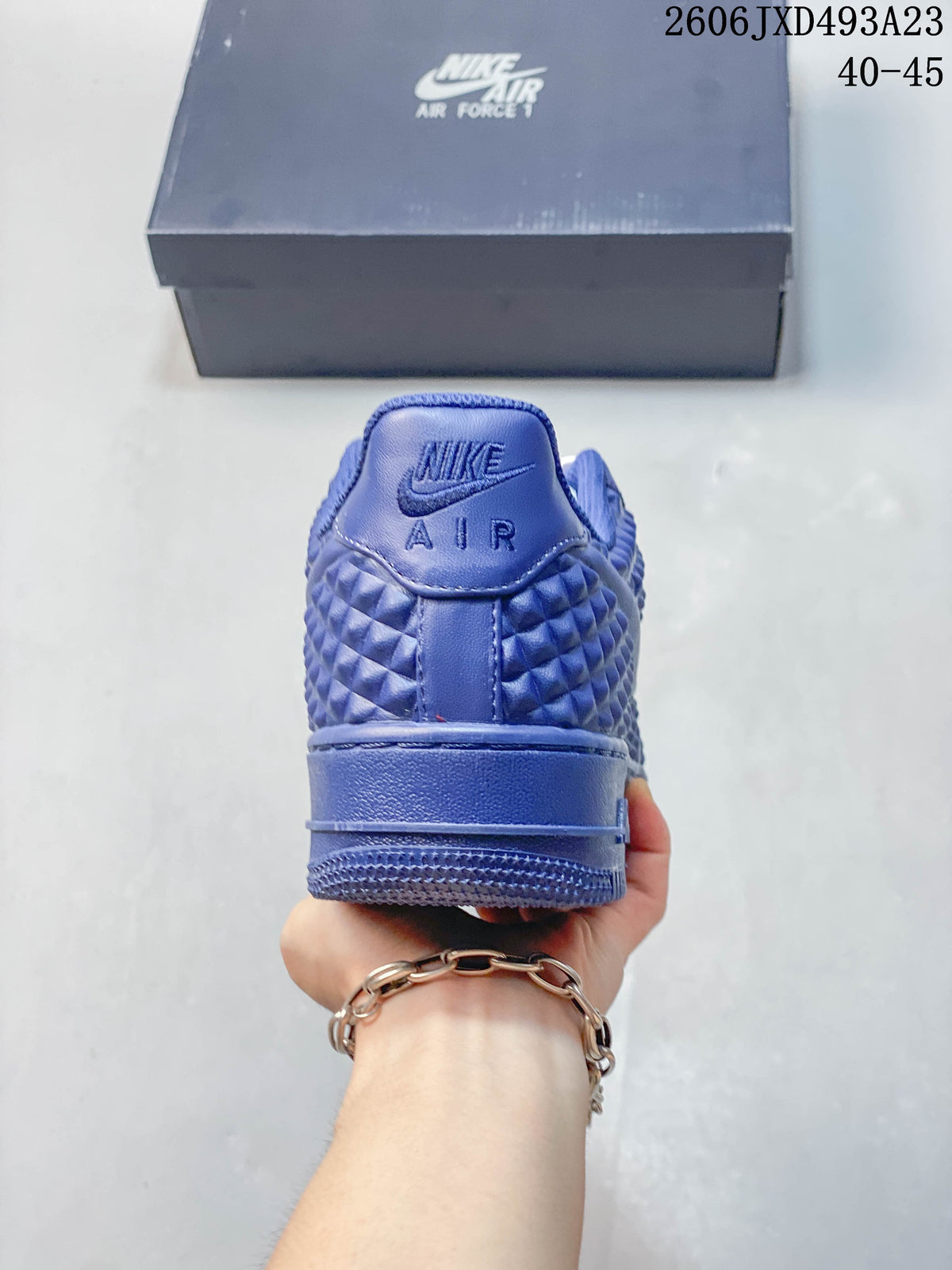 Rear view of a blue Nike Air Force 1 sneaker with textured upper and heel branding