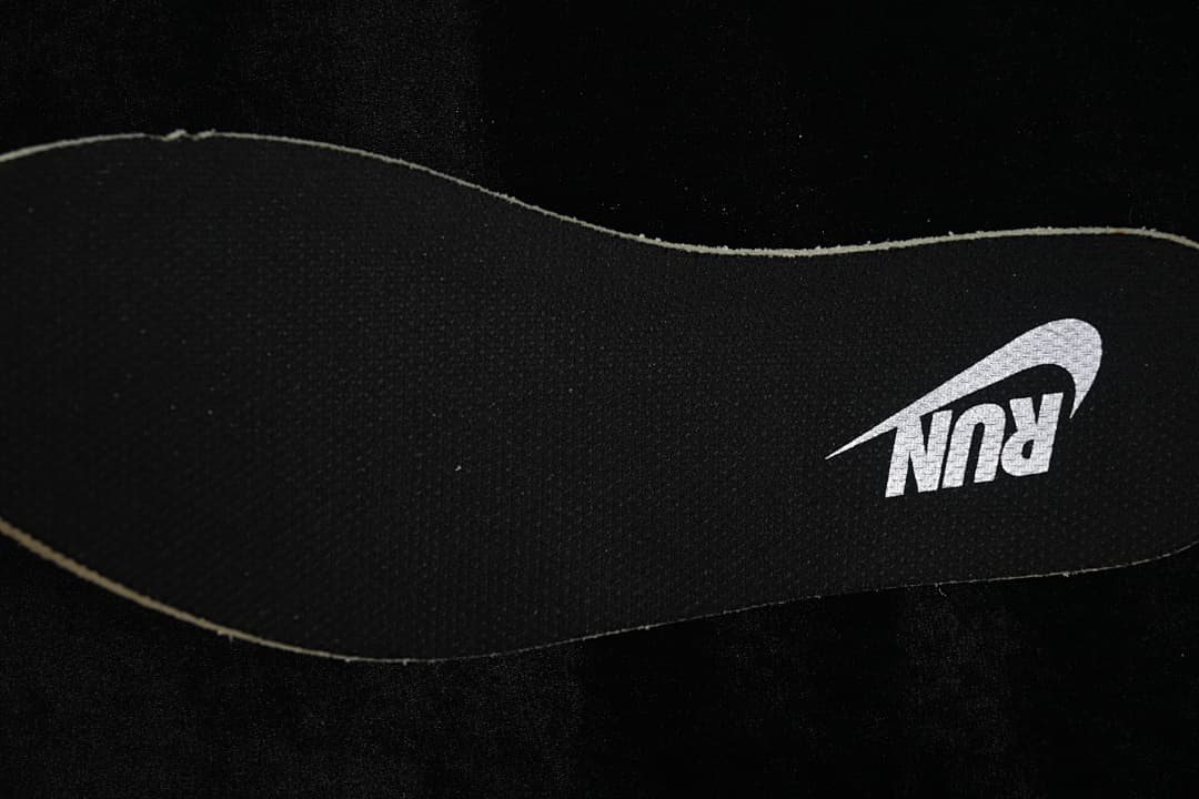 Close-up of a black shoe insole with a white Nike Run logo