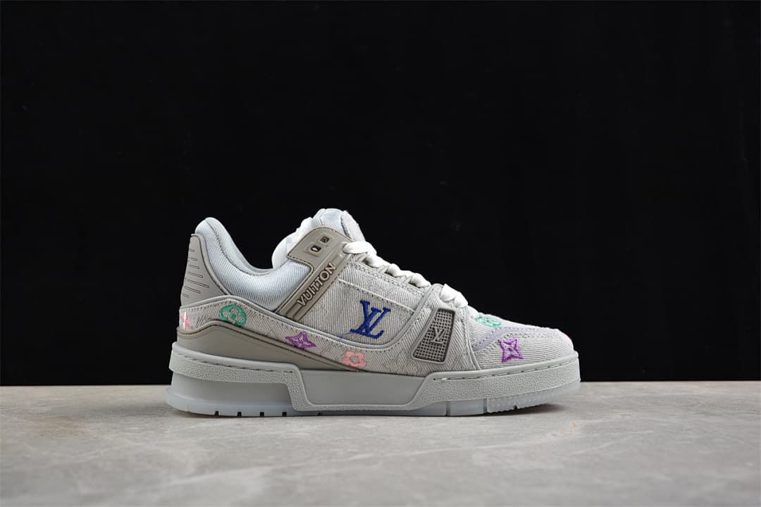 Side profile of a gray LV Trainer sneaker with colorful motifs
