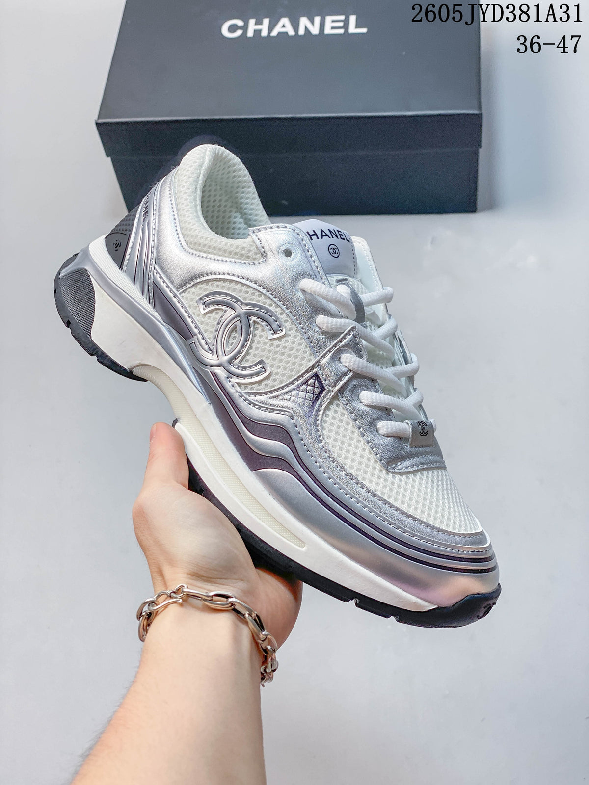 Silver and white chunky sneaker with mesh panels and layered metallic-look overlays