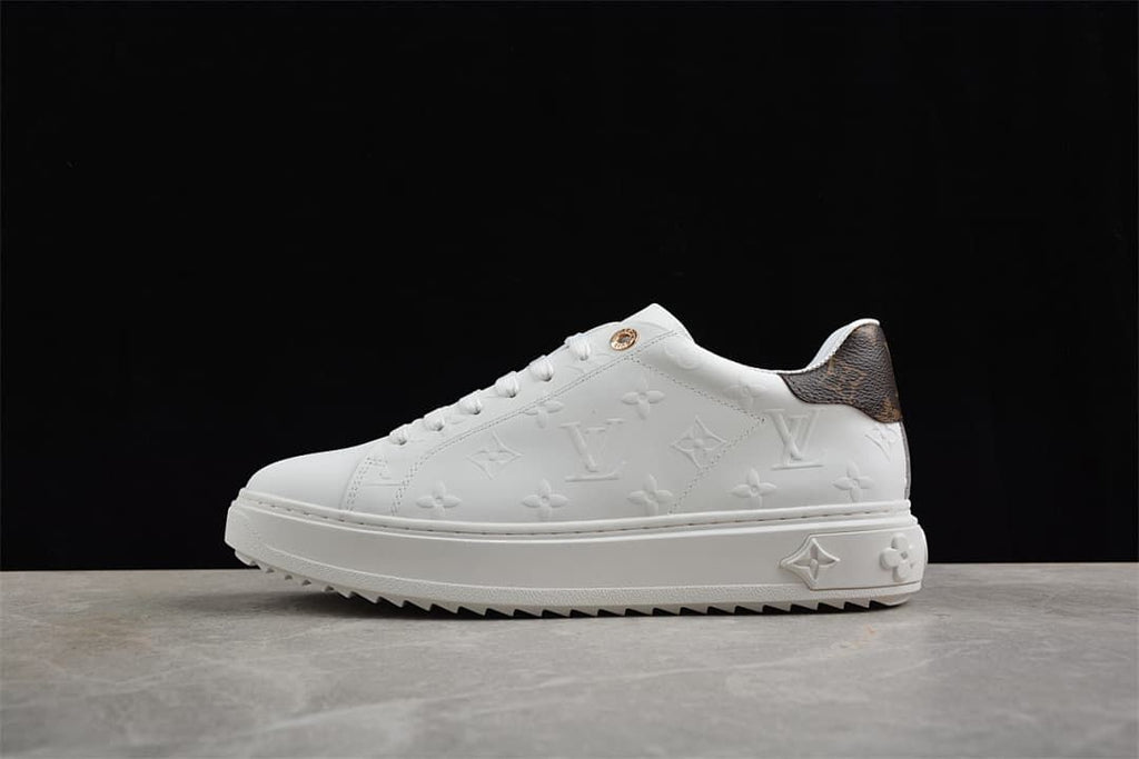 White low-top platform sneaker with embossed motifs and brown patterned heel panel