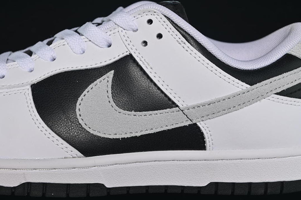 Close-up of the grey Swoosh, black side panel, and white laces