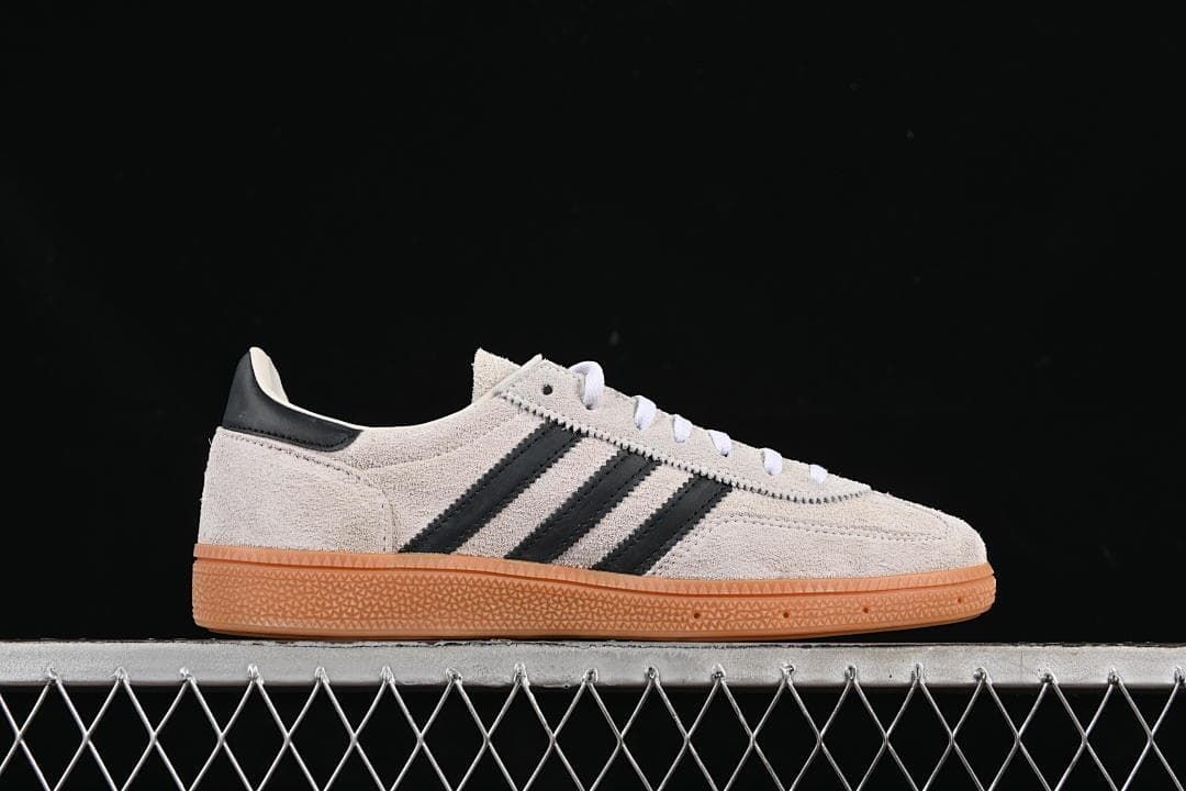 Side profile of the cream sneaker with black stripes and gum sole