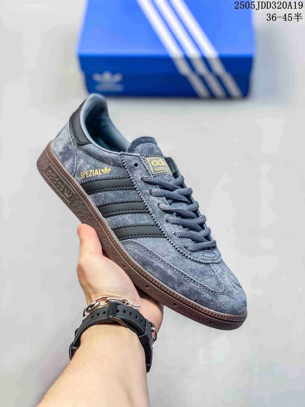 Angled side view of a grey low-top sneaker showing its stripes, gold side branding and gum sole.