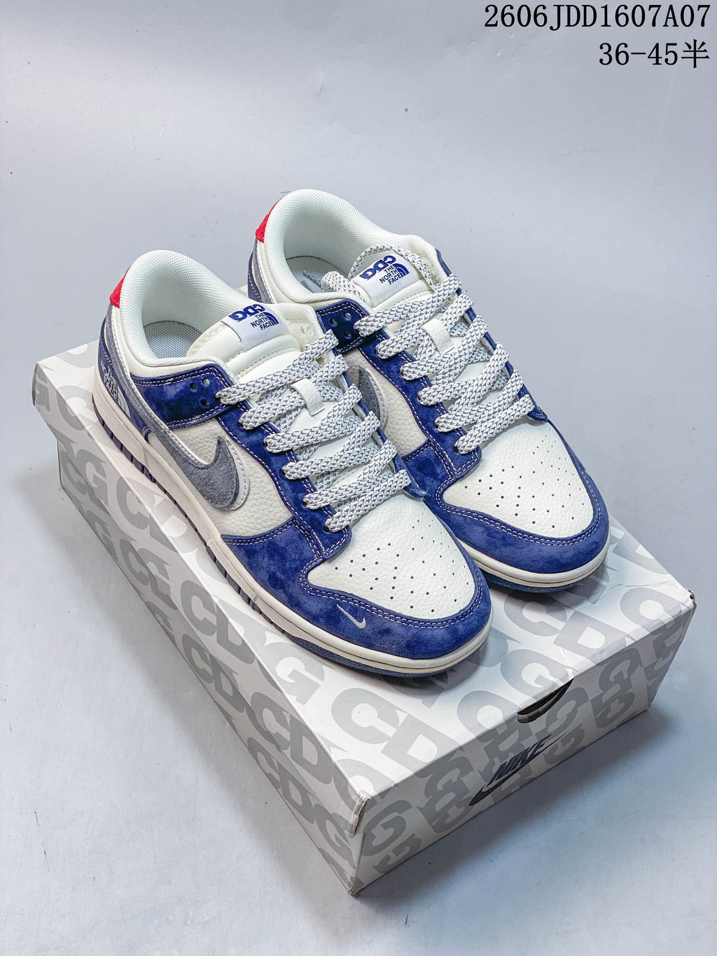 Pair of blue, white, and gray low-top sneakers on a patterned box