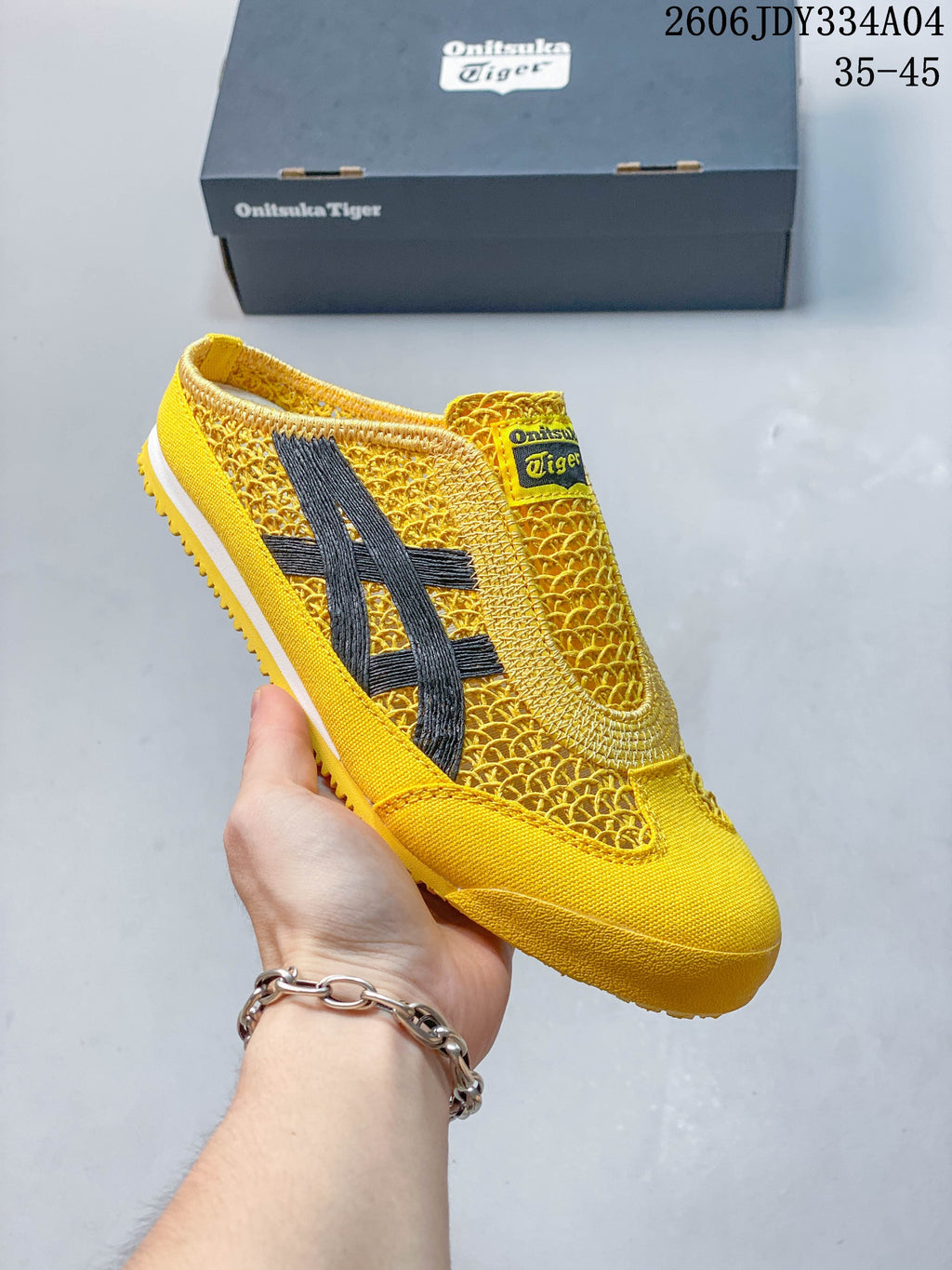 Angled view of the yellow Mexico 66 Sabot slip-on with dark side stripes.