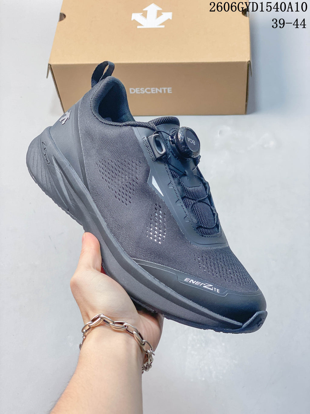 Angled side view of the charcoal DESCENTE running shoe
