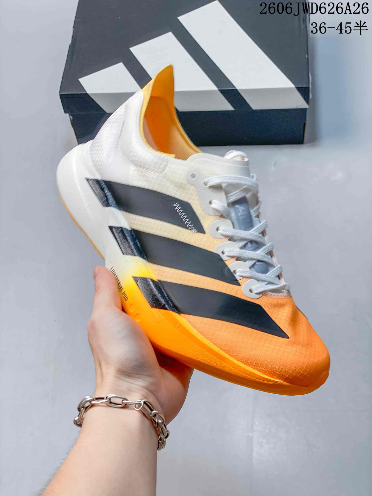 White, black, and orange Adidas Adizero Adios Pro 4 shoe shown from the side.