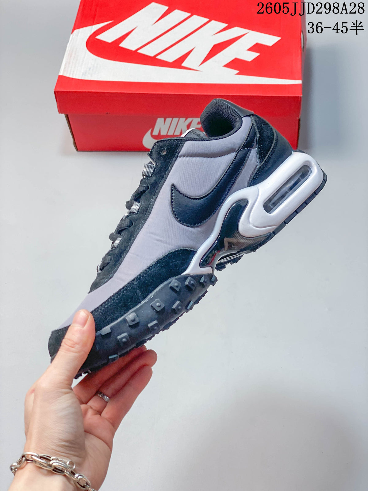 Side profile of a gray and black low-top sneaker with a visible heel unit