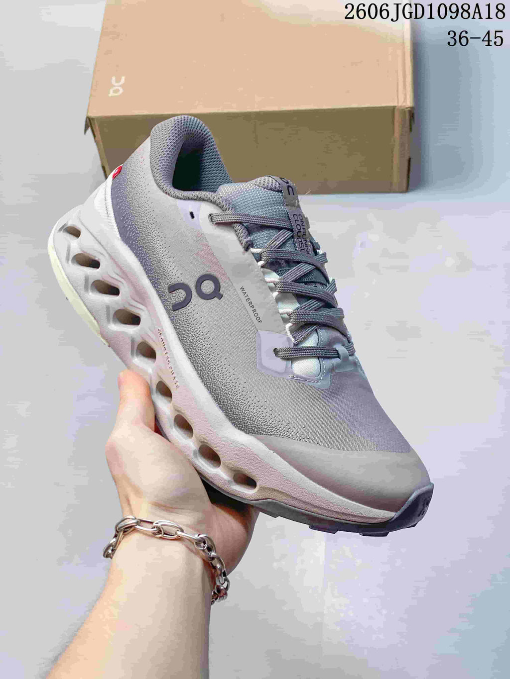 Angled side view highlighting the gray upper, On branding, and sculpted midsole.