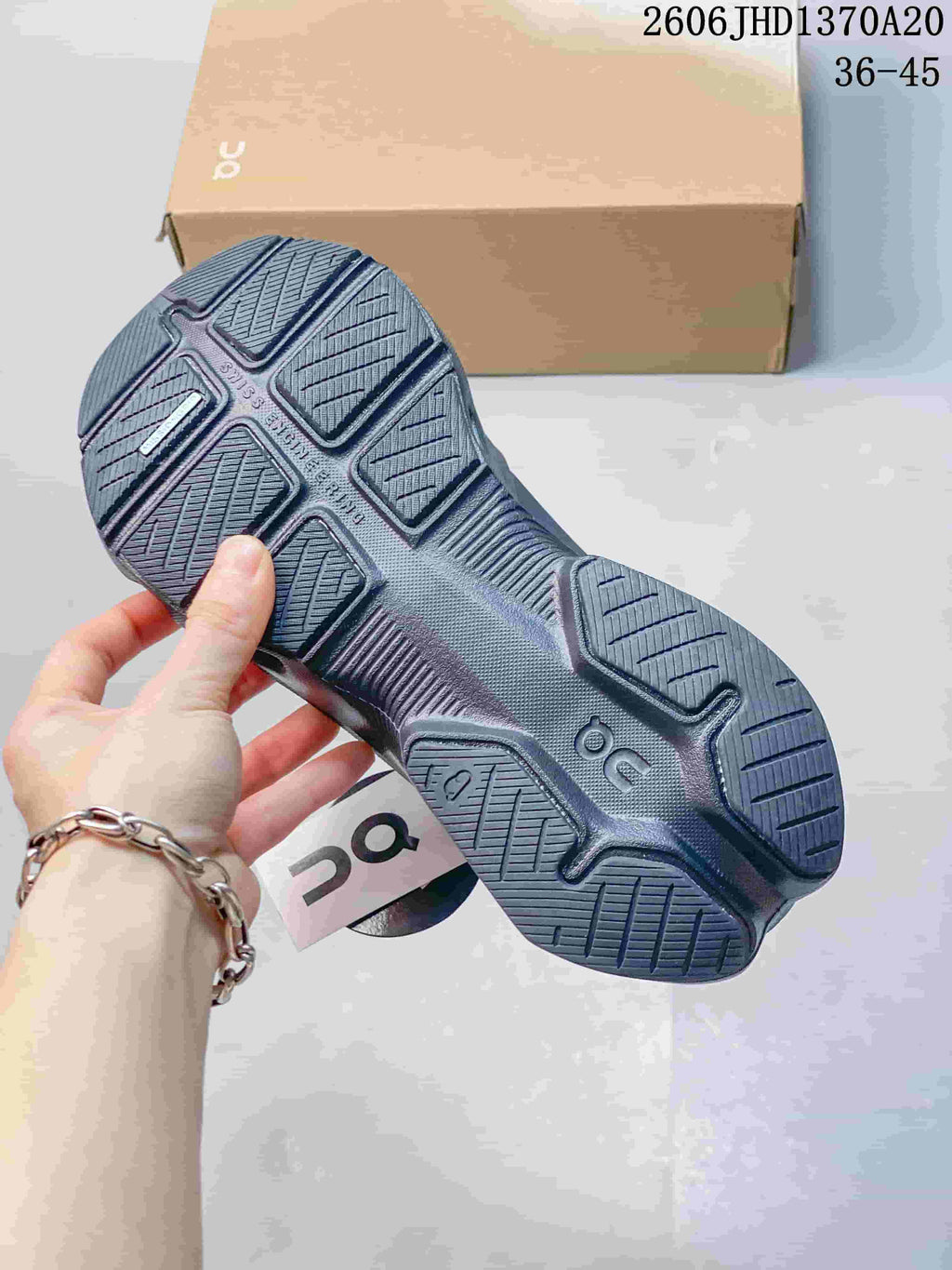 Underside view showing the sculpted tread of a charcoal gray sneaker.