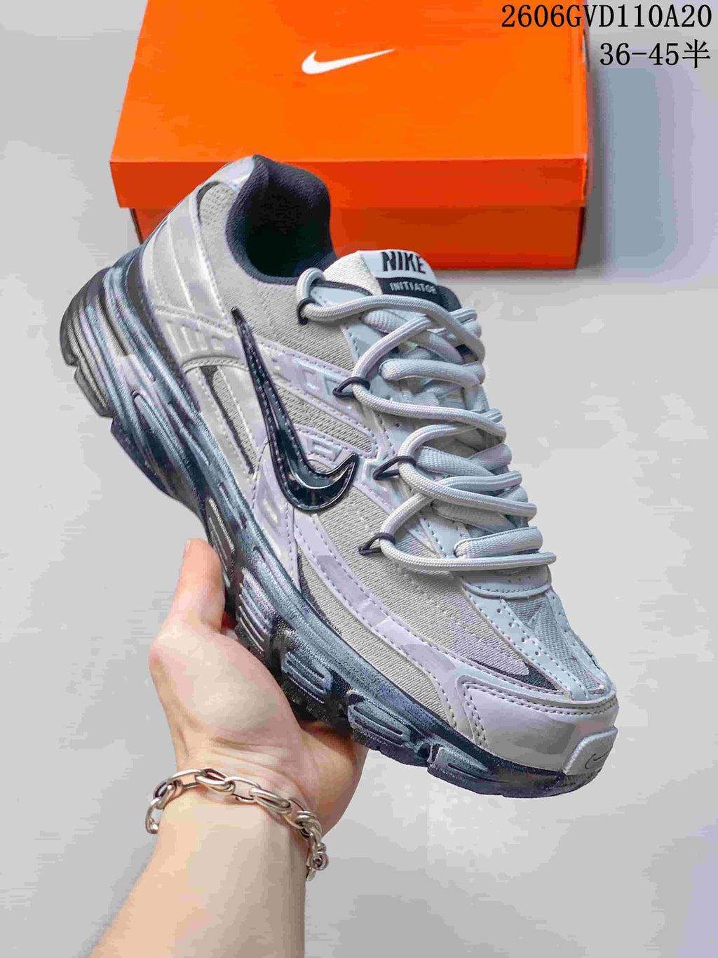 Angled side view of the silver and gray sneaker with dark accents.