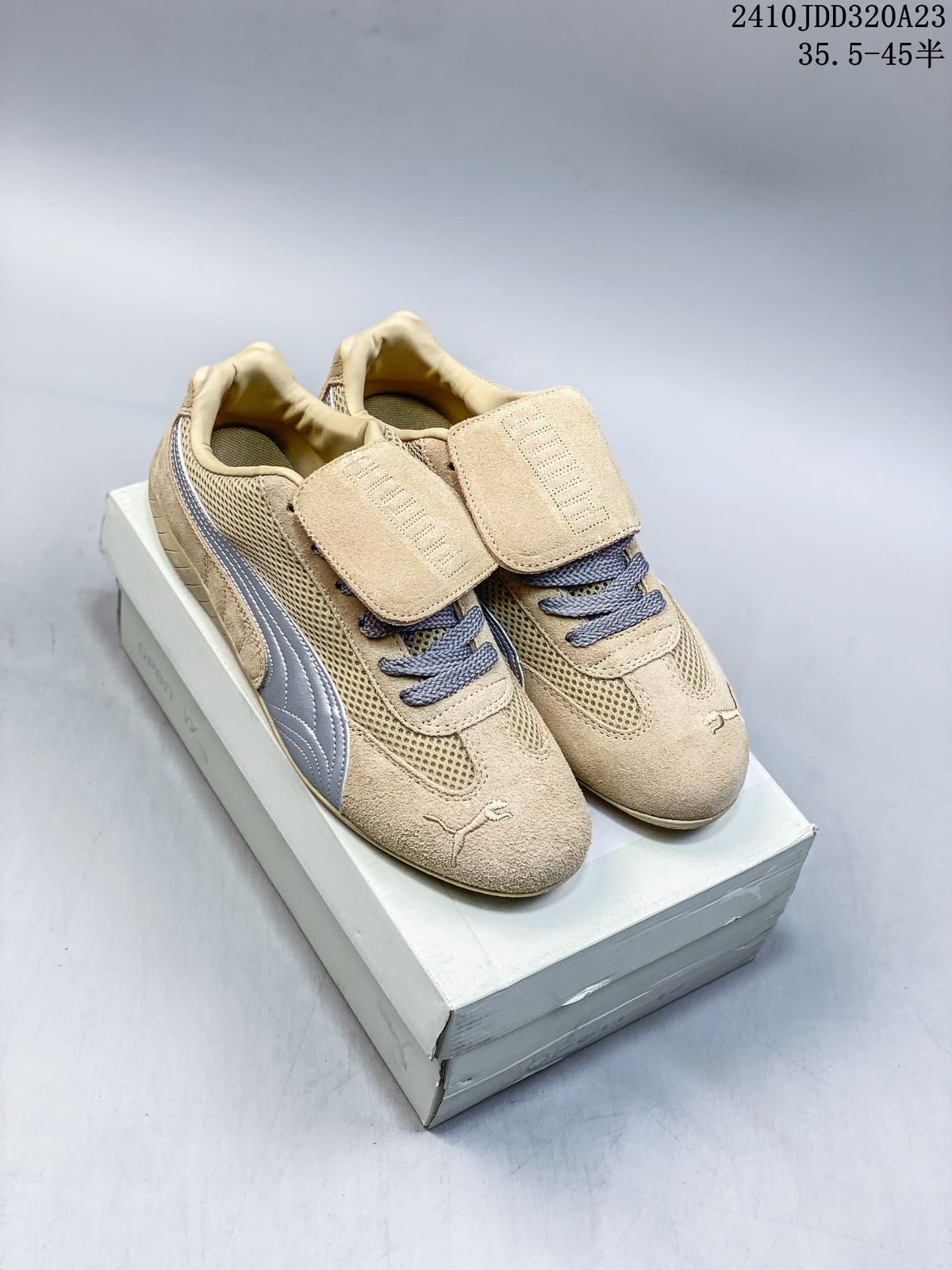 Pair of beige Puma Speedcat sneakers with silver side stripes, gray laces, and removable lace flaps.