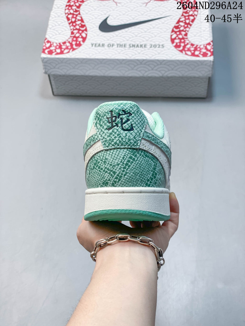 Rear view of the sneaker showing snake-scale patterned heel details and a snake character